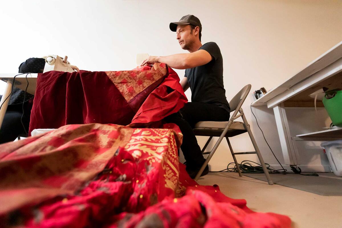 Man sews a rug